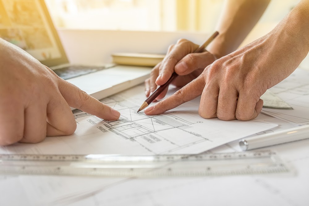 Hands of Engineer working on blueprint,Construction concept. Engineering tools.Vintage tone retro filter effect,soft focus(selective focus) Home Renovation Costs Guide