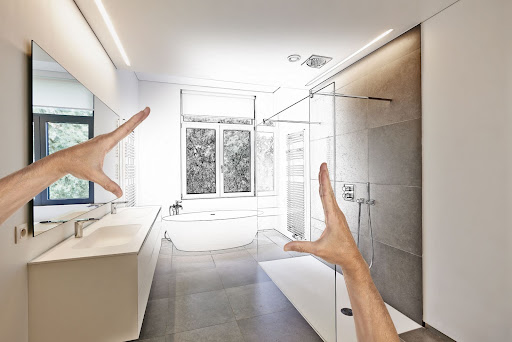 A pair of male hands outlining a bathroom in which the middle is hand-drawn to show the potential renovation ideas - Bathroom Remodel Costs Lancaster Guide
