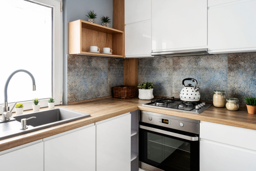 small kitchen design with clean wood countertops and shiny white cupboards that make the space feel more spacious - Small Kitchen Remodeling
